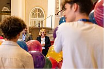 Personen von hinten unscharf, Luftballons und eine lächelnde Frau