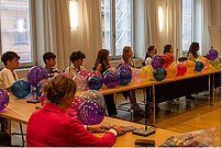 Sprecherin und Zuhörende an Tischkreis mit Luftballons - nähere Ansicht